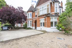 a large brick house with a driveway in front of it at Stunning 4-Bed Property in London-Parking & Garden in London