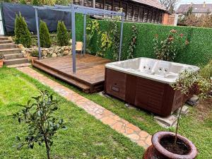 eine Badewanne auf einem Hof neben einer Holzterrasse in der Unterkunft Mirka in Sremski Karlovci