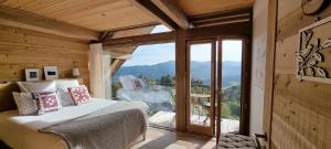 1 dormitorio con cama y ventana grande en Chalet La Petite Ourse en Hohrod