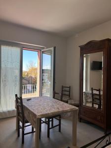 a dining room with a table and a large window at L'INCANTO CASA VACANZE in Montegrosso dʼAsti