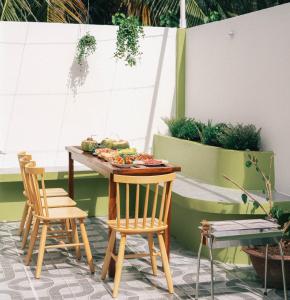 una mesa con sillas y comida en el patio en Entire House - Nhà nguyên căn - Nhà Mơ Homestay Bến Tre, en Ben Tre