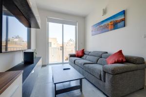 a living room with a couch and a large window at Contemporary 3BR Retreat in Prime Sliema in Sliema