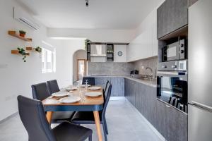 una cucina con tavolo e sedie in legno in una stanza di Contemporary 3BR Retreat in Prime Sliema a Sliema