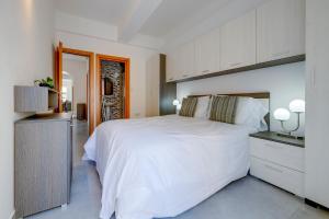 een slaapkamer met een groot wit bed en een keuken bij Contemporary 3BR Retreat in Prime Sliema in Sliema