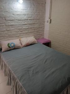 uma cama grande num quarto com uma parede de tijolos em ALQUILER TEMPORARIO LU-KA em Presidencia Roque Sáenz Peña