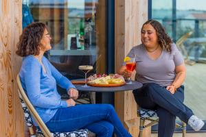 勒阿弗爾的住宿－The People Le Havre，两个女人坐在桌子边,喝一杯酒