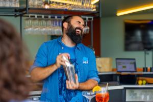 Ein Mann steht in einer Küche und rührt einen Drink. in der Unterkunft The People Le Havre in Le Havre