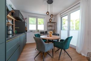 a kitchen with a table and green chairs at Ferienwohnung "Haffhafen" Hunde willkommen in Zirchow