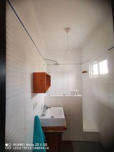 a white bathroom with a sink and a window at Campo y lava in Tías