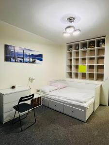 1 dormitorio con cama, escritorio y silla en Near airport cybernetyki Inn, en Varsovia