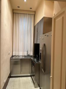 a kitchen with a stainless steel refrigerator next to a window at Residenza del Corso in Arezzo