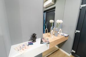 Un escritorio blanco con espejo y flores. en Jana House Oriovac en Oriovac