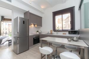 a kitchen with a refrigerator and a table and chairs at Lodging Sant Pau Views- Suite with View on Hospital Sant Pau in Barcelona