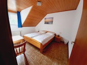 sypialnia z łóżkiem, stołem i oknem w obiekcie Pension Dorfengel w mieście Berolzheim