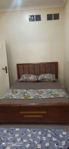 1 dormitorio con 1 cama con cabecero de madera en dreamHome en Sétif