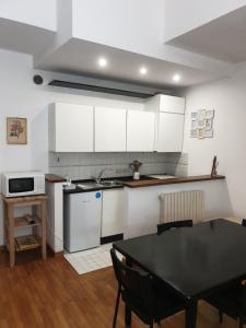 kuchnia z białymi szafkami, czarnym stołem i tableablish w obiekcie Residence Vanvitelli w mieście Ancona