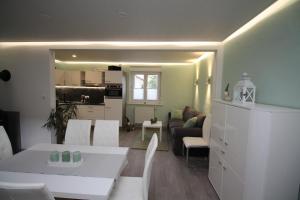 a living room with a white table and a kitchen at Ferienwohnung Benkertshof 