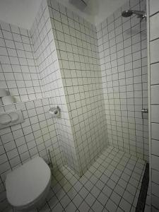 ブダペストにあるJazz Apartmentの白いタイル張りのバスルーム(トイレ、シャワー付)