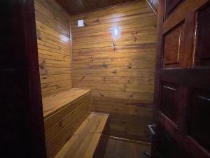 una sauna de madera con puerta de madera en una habitación en Chalé Caiçara, en Caraguatatuba