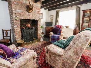 a living room with two couches and a stone fireplace at Wharf Cottage in Llangollen