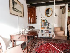 a living room with a table and a staircase at Wharf Cottage in Llangollen