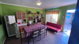 uma sala de jantar com uma mesa e um sofá vermelho em Cota6000 Expediciones Dpto B em San Pedro de Atacama