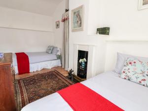 a bedroom with two beds and a fireplace at Wharf Cottage in Llangollen