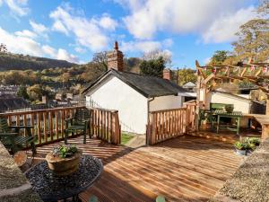 a wooden deck with a table and chairs on it at Wharf Cottage in Llangollen