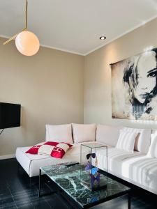 a living room with a white couch and a glass table at Het huis van Hermens in Meerssen