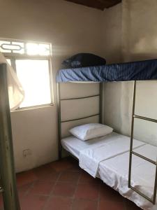 um pequeno quarto com 2 beliches e uma janela em RiverMan Hostel, Tourism and Friends em Jagua