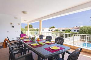 a dining room with a table and chairs and a balcony at Villa Santo Grande by Villa Plus in Santo Tomás