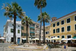 a street with palm trees and tables and umbrellas at Villa Santo Grande by Villa Plus in Santo Tomás