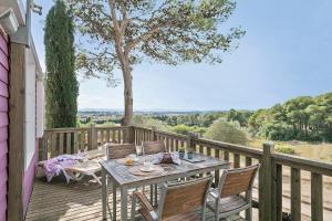a wooden deck with a table and chairs on it at Càmping Castell Montgrí **** in L'Estartit