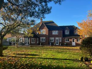 a large brick house with a tree in the yard at Brackenborough Lakes Resort in Louth