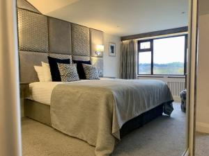 a bedroom with a large bed with a large window at Mill Park Hotel in Donegal