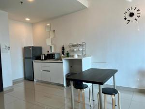 una cocina con mesa negra y sillas. en Welcome Suite at Trefoil Setia Alam, en Shah Alam 4 fotos más