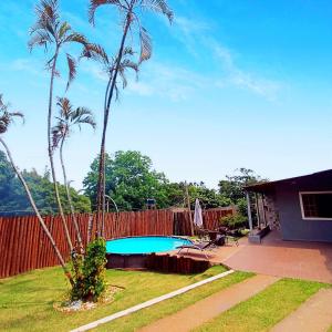 a swimming pool in a yard with palm trees at Espaço Tranquilum in Sorocaba
