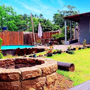 a garden with a stone wall and a swimming pool at Espaço Tranquilum in Sorocaba