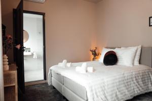 a bedroom with a white bed with a mirror at Hotel bij Jacob in Enschede