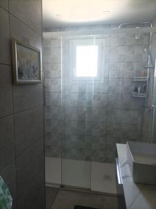uma casa de banho com um chuveiro, uma janela e um lavatório. em Maison proche circuit 24 heures du mans em Spay