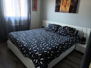 uma cama com um edredão e almofadas num quarto em Maison proche circuit 24 heures du mans em Spay