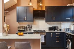 a kitchen with black cabinets and a counter top at Homebird Property - Haddon House in Leeds