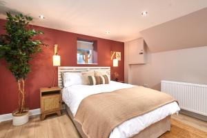 a bedroom with a large bed with red walls at Homebird Property - Haddon House in Leeds