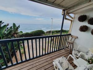 a balcony with a view of the ocean at Cottage On the Beach in Umdloti