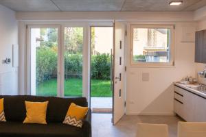 uma sala de estar com um sofá e uma cozinha com portas de vidro deslizantes em HouSmart Toscana 53 White em Bolonha