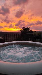 a hot tub with a sunset in the background at STUDIO CASA FERMEGLIA for two people in Roč
