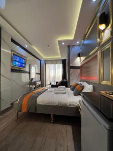 a bedroom with a large bed and a flat screen tv at Taksim Larissa hotel suites in Istanbul