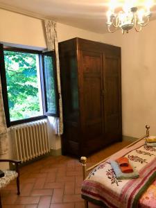 1 dormitorio con cama y ventana grande en Spacious house with private garden in Chianti, en Lucolena in Chianti