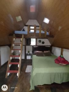 a room with a bed and bunk beds in a attic at Cabaña bosque río celeste in San Rafael