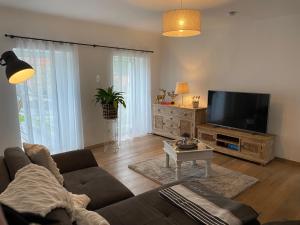 a living room with a couch and a flat screen tv at Ferienhaus Burgblick in Stadtschlaining in Stadtschlaining